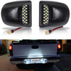 A pair of high brightness 18 LED license plate lights for trucks shown alongside an installed light on a silver pickup truck.