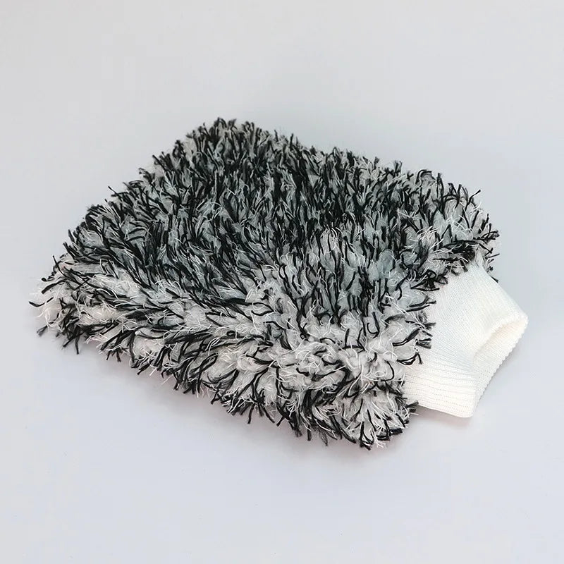 A fuzzy black and gray microfiber cleaning glove with a white cuff.