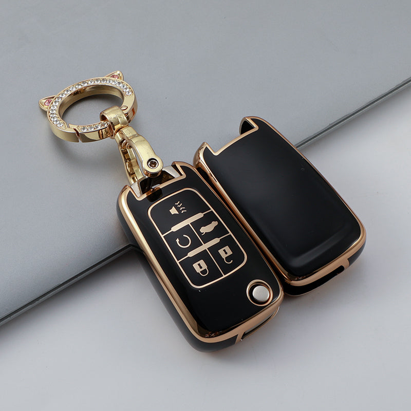 A gold-toned key fob with a clear crystal ring and a black durable TPU case featuring multiple buttons.