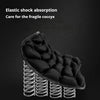 A black elastic shock absorption pad designed for care of the fragile coccyx, shown with coiled springs.