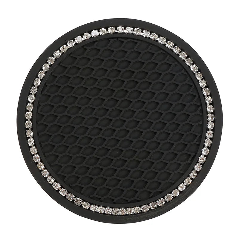 Posavasos de silicona negra con superficie texturizada y borde de pedrería plateada ornamentada.