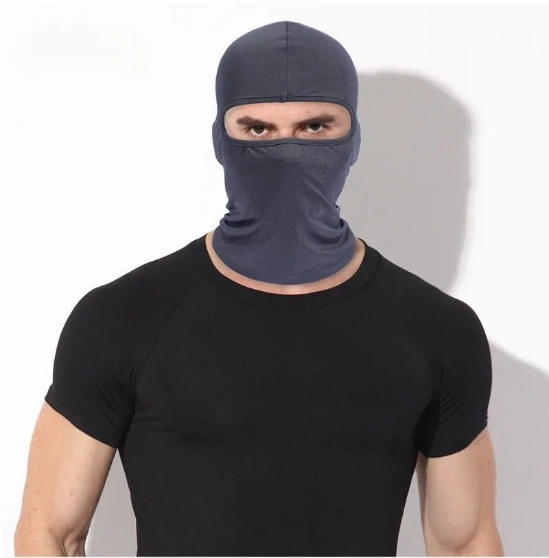 A man wearing a dark blue balaclava face mask and a black t-shirt.