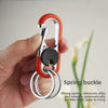 A hand holds a red spring buckle lock carabiner keychain with a silver ring.