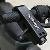 Primer plano de un seguro de freno antirrobo negro para bicicletas y patinetes con agarre texturizado.