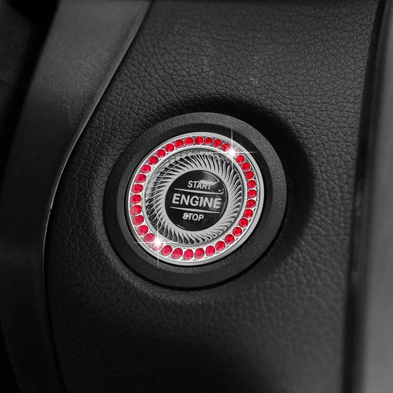 Close-up of a decorative ignition push button cover featuring a central circular design with red lights and the text START EN
