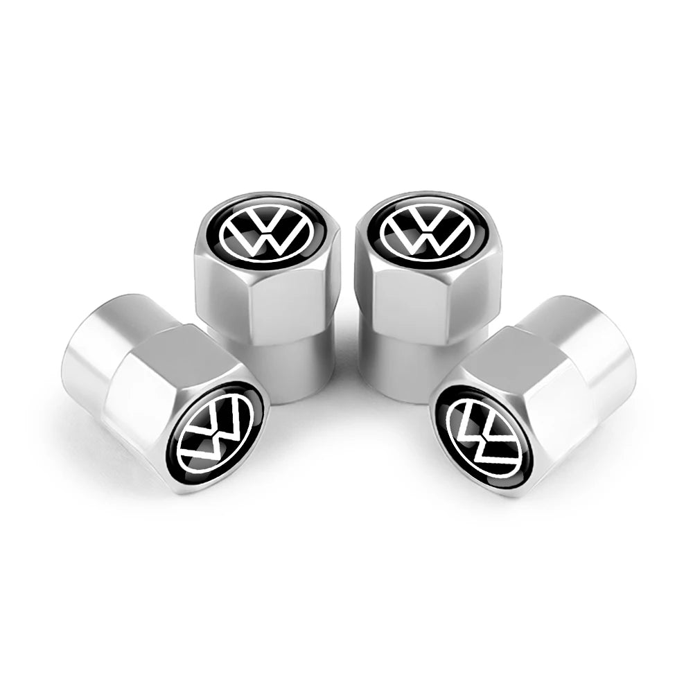 Three silver metal tire valve caps with VW logos displayed on a white background.