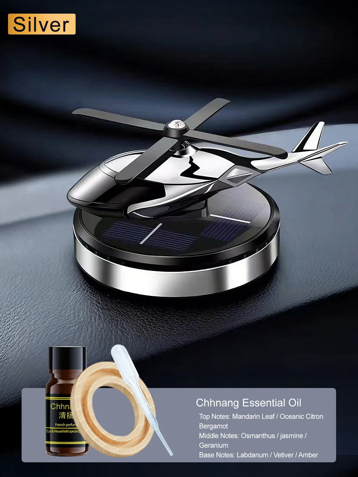 Parfum voiture solaire argenté rotatif avec une hélice et une lumière LED sur une surface sombre.