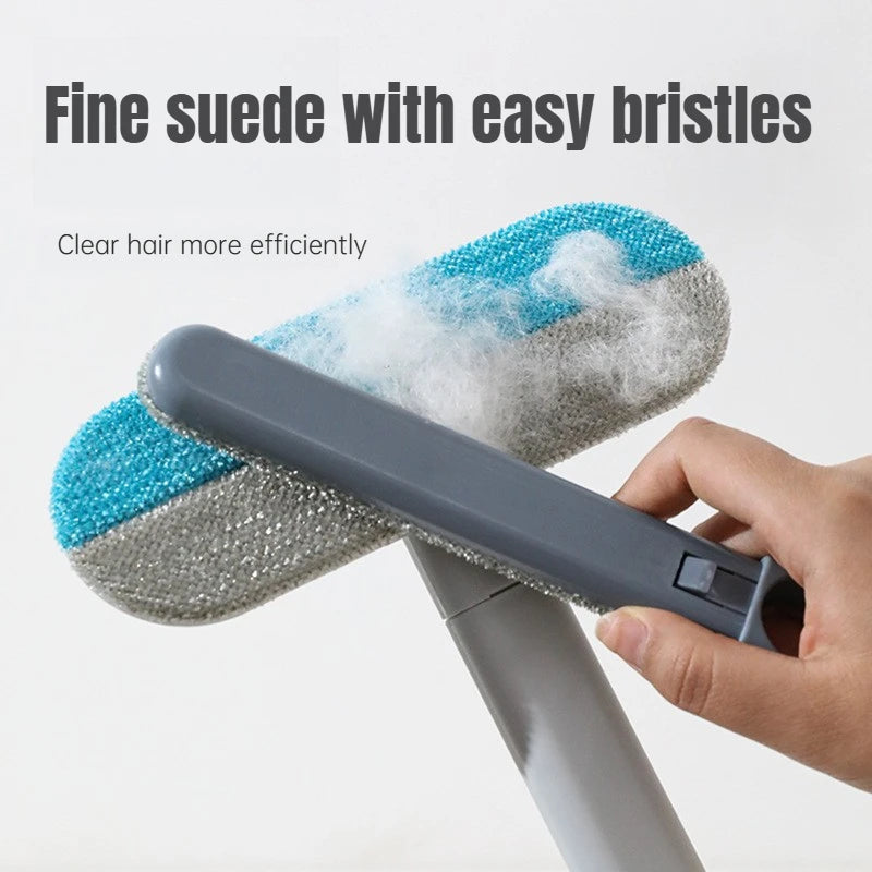 A hand holds a long-handled static pet hair remover brush with blue bristles, demonstrating its use for clearing hair.