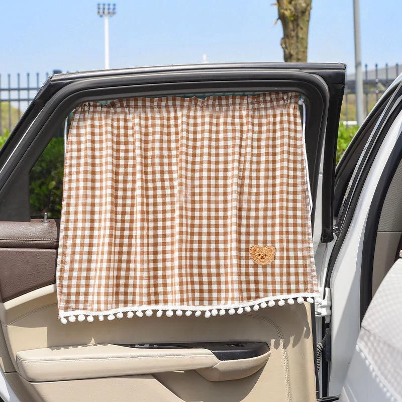 Un protector solar a cuadros marrón y blanco instalado en la ventana trasera de un coche.