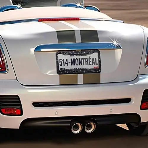 A white car with a diamond rhinestone license plate frame displaying the text 514 MONTREAL.