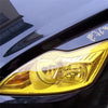 Close-up of a golden yellow PVC tint film applied to a car's headlight assembly.