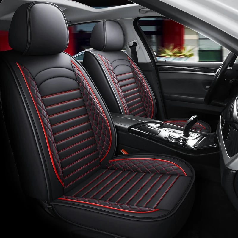 Interior view of a car showing black leather seats with red stitching and a matching seat cushion.