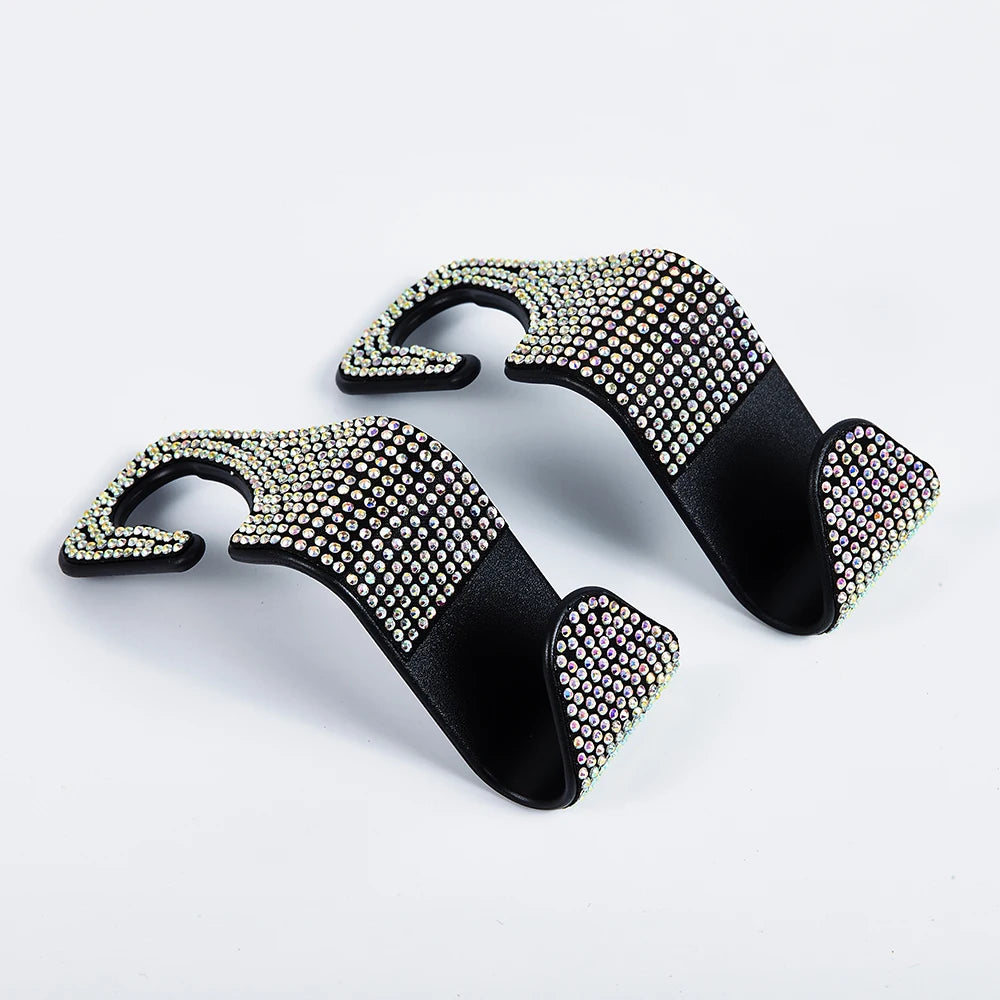 A pair of black car hooks adorned with sparkling artificial diamonds for storage.