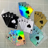 A collection of colorful playing cards, including aces and hearts, arranged on a transparent surface.