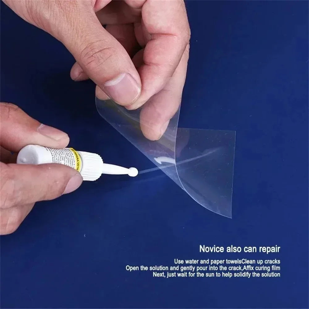 A hand applies a clear film solution to repair a windshield crack on a blue surface.