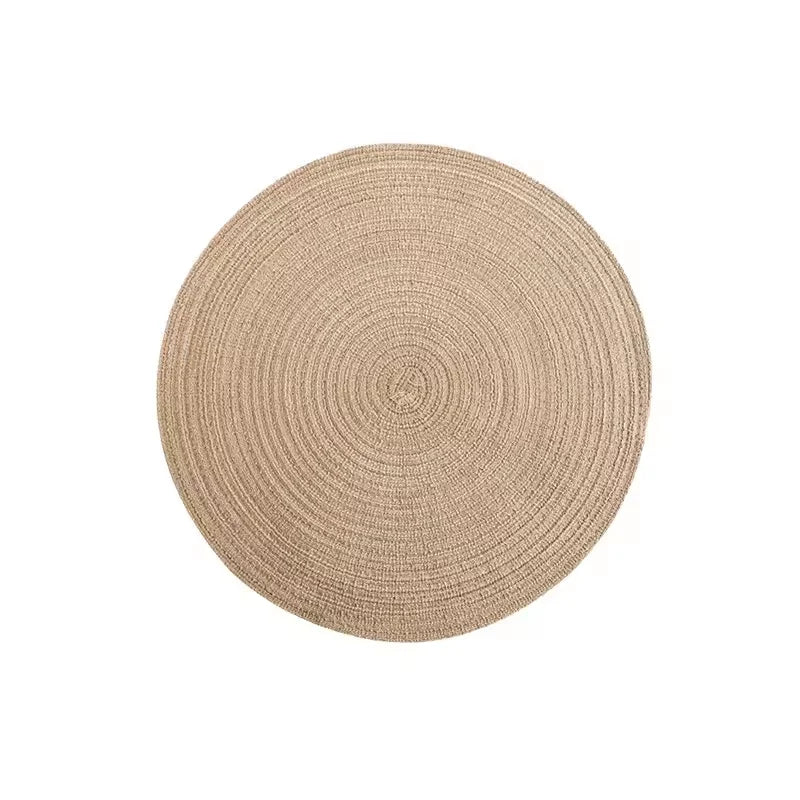 Round beige woven placemat made of cotton yarn with concentric circular texture
