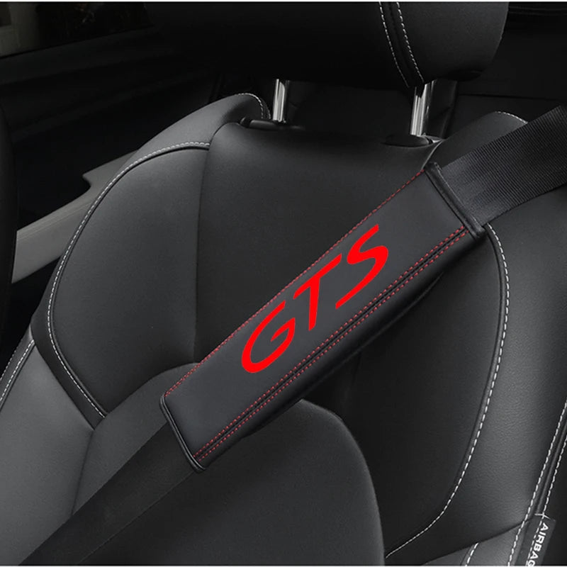 A black seat belt protector cover with GTS branding is shown on a car seat.