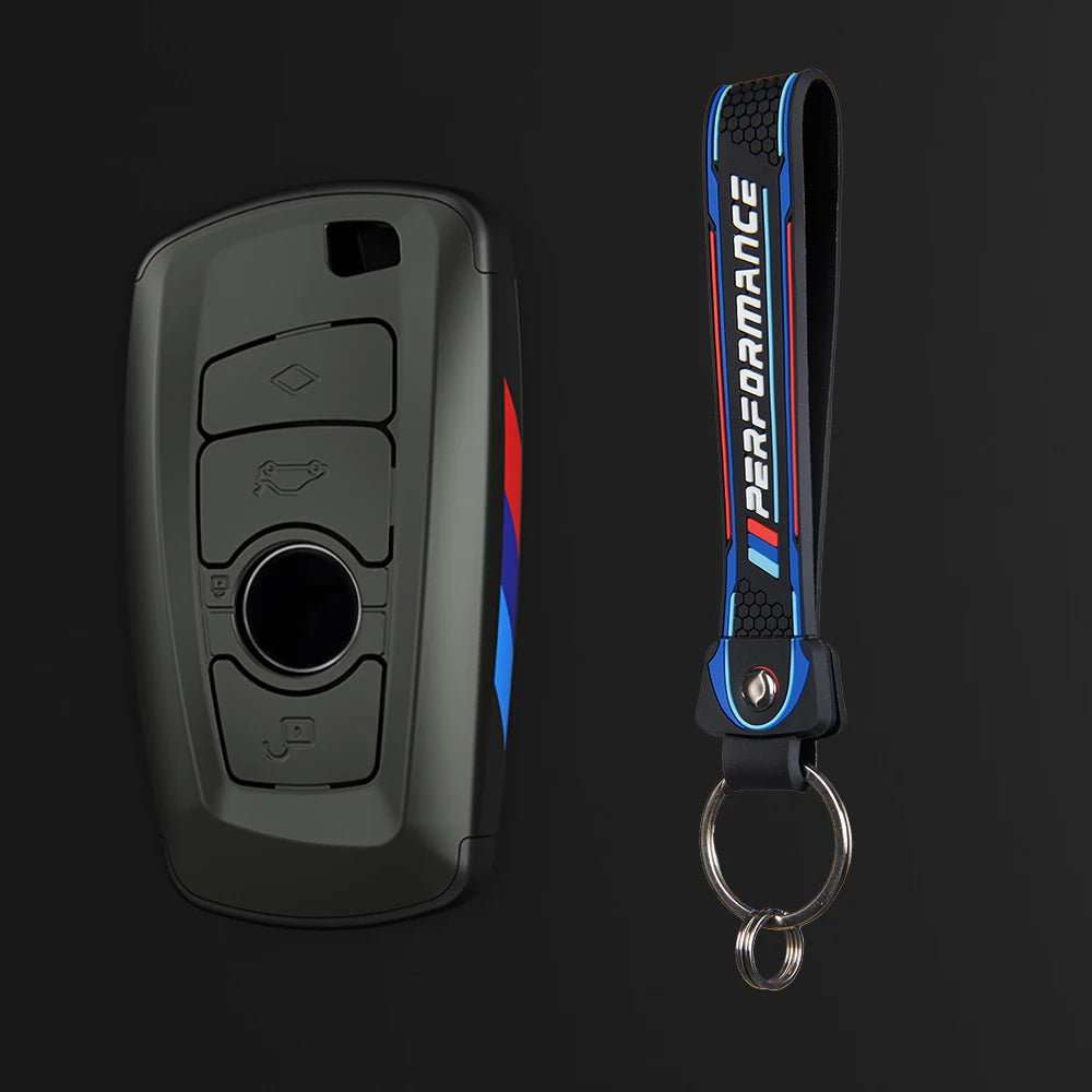Un juego de fundas para llaves de coche negro con diseño azul y rojo, visto en primer plano.