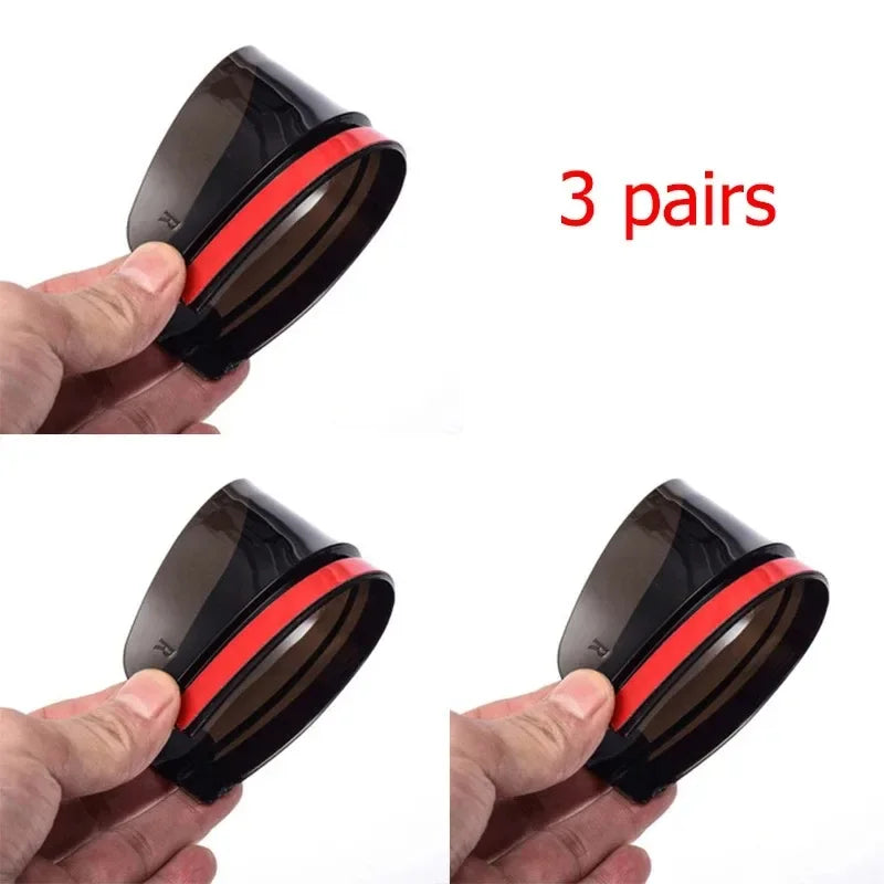 Three pairs of black carbon fiber car rain visors being held by a hand.