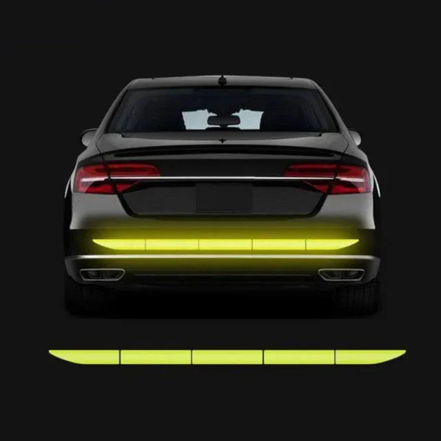 Rückansicht eines dunklen Autos mit leuchtend gelben reflektierenden Sicherheitsstreifen am unteren Stoßfänger.
