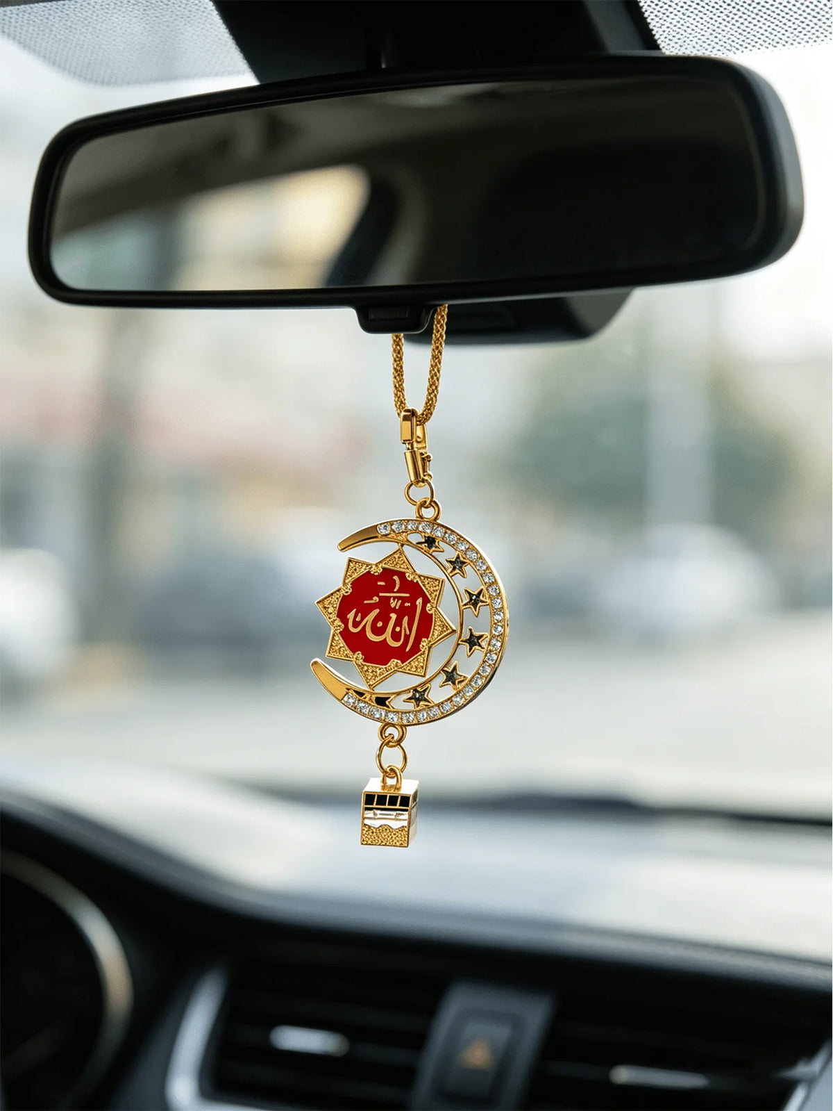 Goldener Anhänger mit islamischer Kalligrafie und Stern-Design, hängt am Rückspiegel.