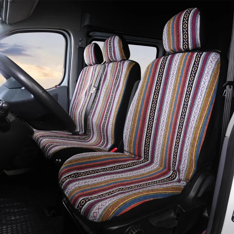 A close-up view of a van interior showing a striped universal seat cover set on the driver's seat.