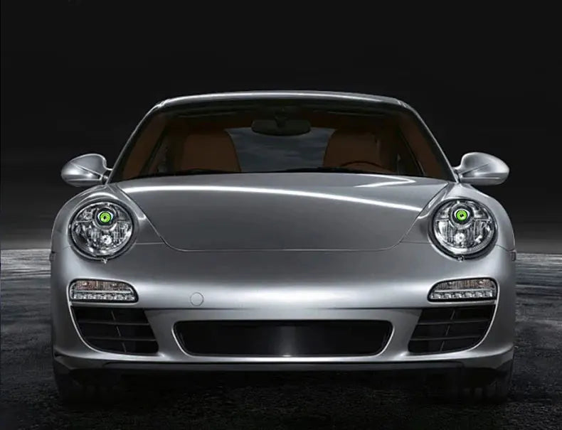 A silver Porsche sports car with dynamic LED eye lights is shown from the front in a dark studio setting.