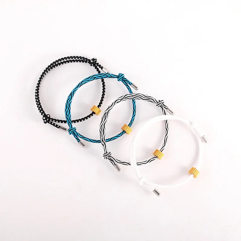 A collection of black, blue, and white heart-shaped fitness tracker bracelets laid out on a white background.