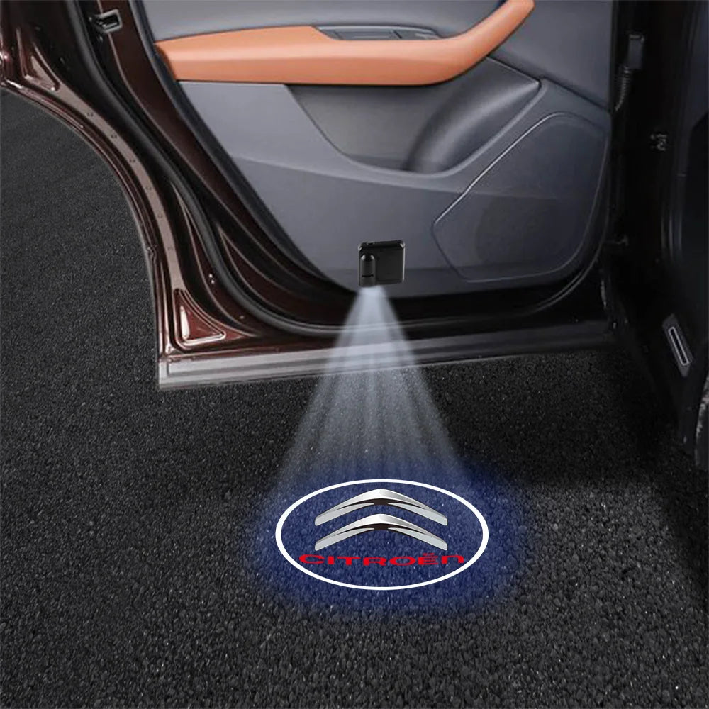 Wireless LED projector shining a light with the Citroën logo onto the ground near a car door.