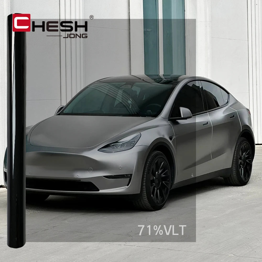 Une Tesla Model 3 argentée avec un film teinté foncé sur les vitres.