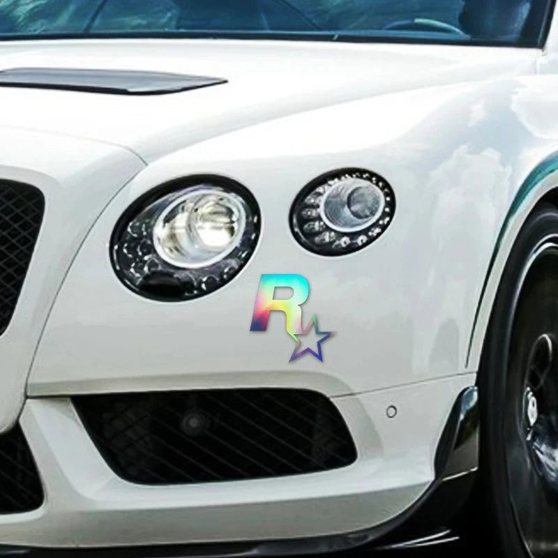 Close-up of a white car's headlight assembly with a reflective 5-point star decal applied to the front bumper.