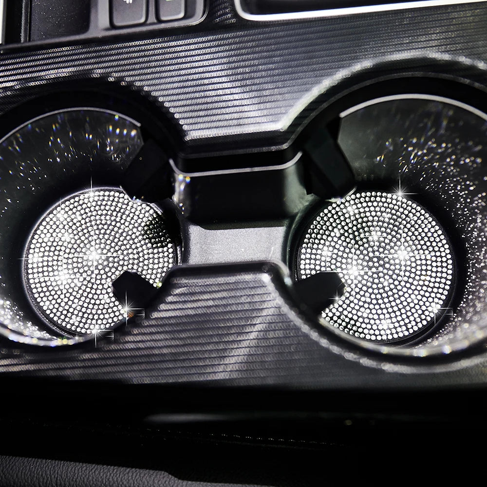Close-up view of two clear glass coasters with diamond-cut patterns set in a dark holder.