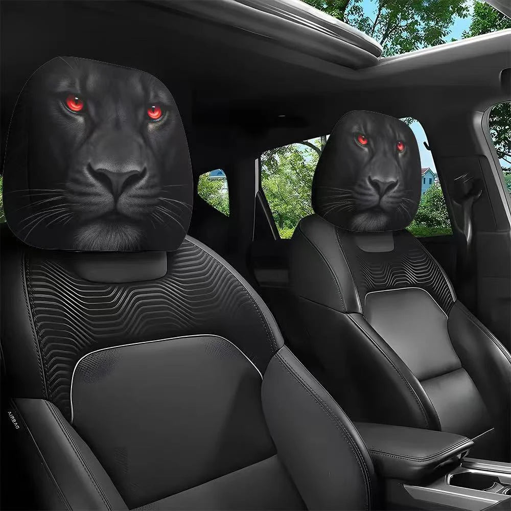 Two black faux leather car headrest covers with slanted red eyes installed in a vehicle interior.