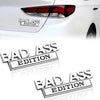 A close-up of a red taillight with a Bad Ass Edition logo decal applied to the exterior of a white car.