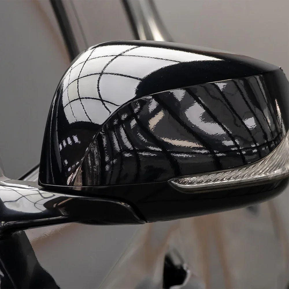 Close-up of a glossy black car wrap film decal on a vehicle surface.