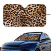 A leopard print car sunshade fitted onto the windshield of a blue car.