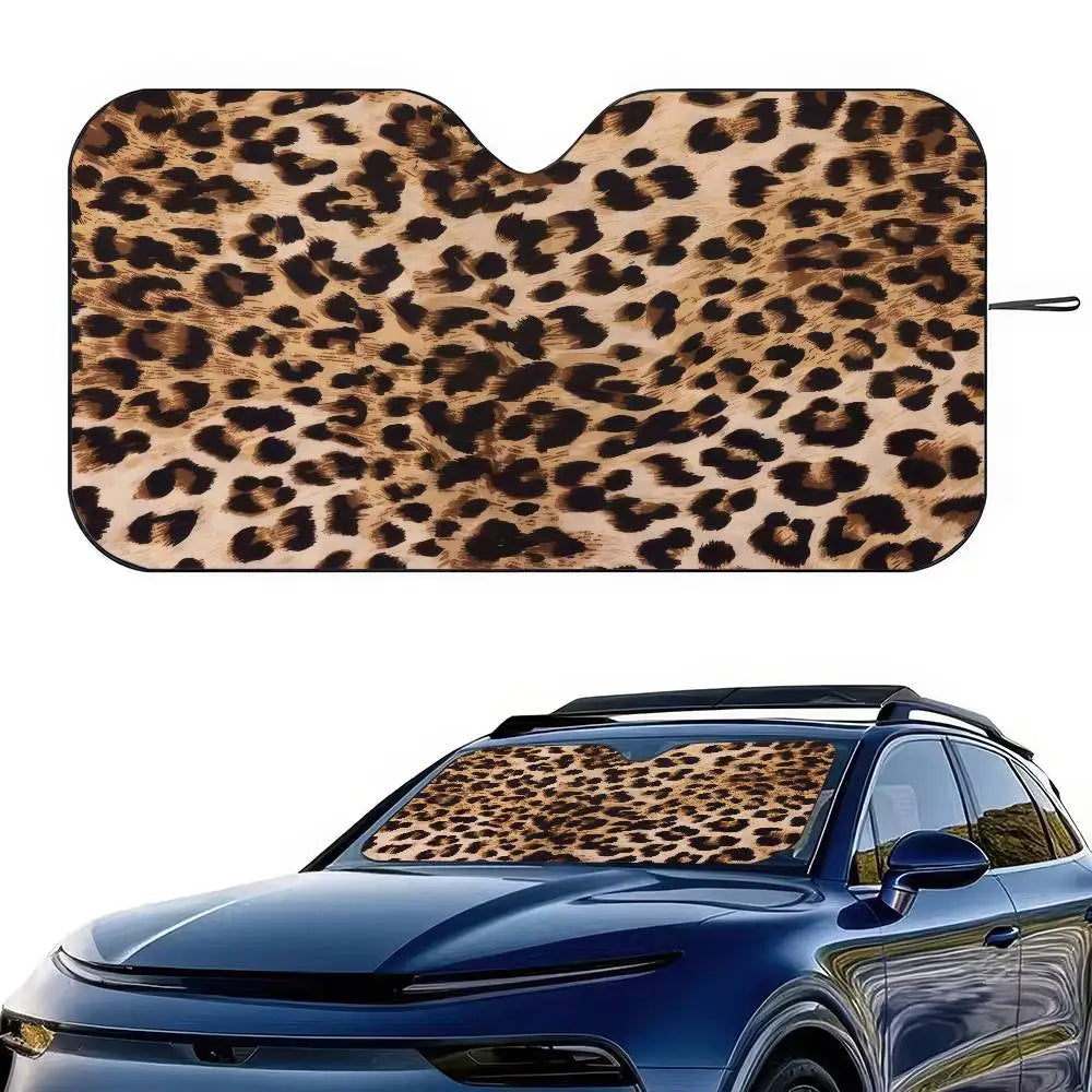 A leopard print car sunshade fitted onto the windshield of a blue car.