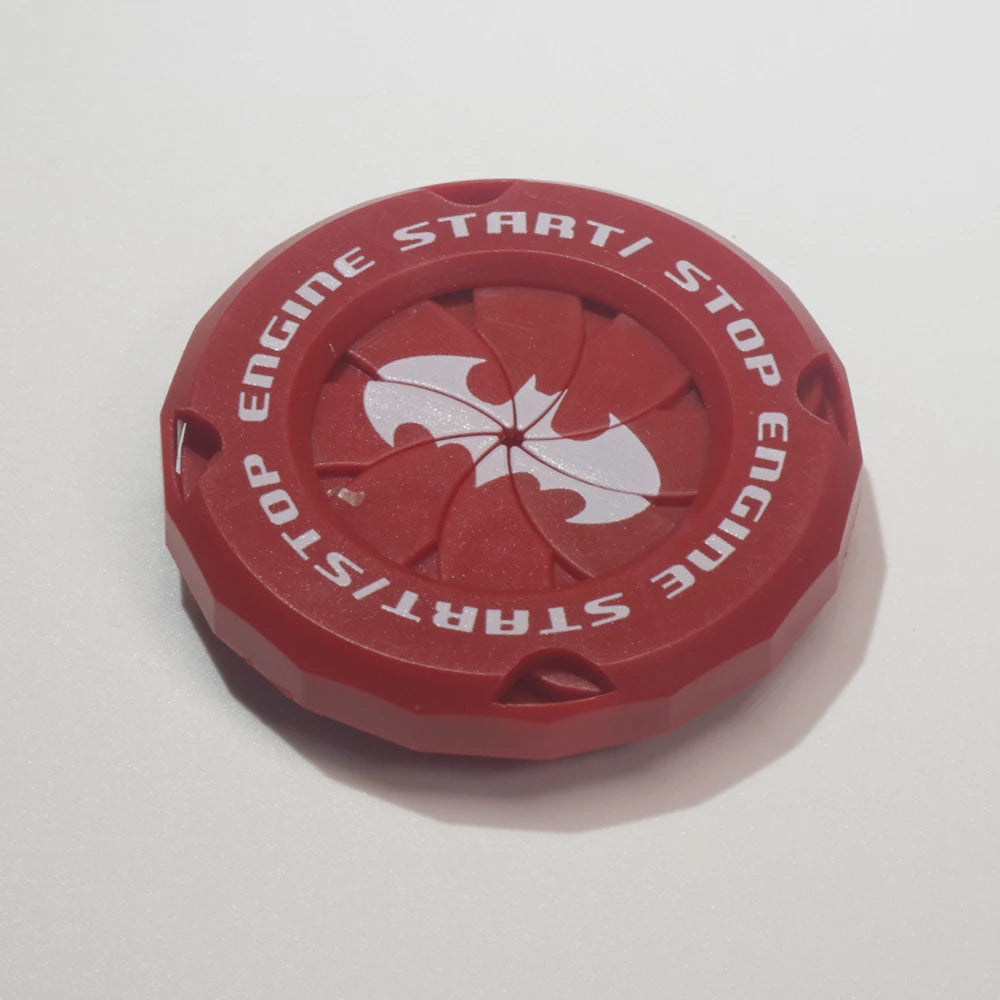 A red decorative car start button cover with white text indicating engine start and stop functions.