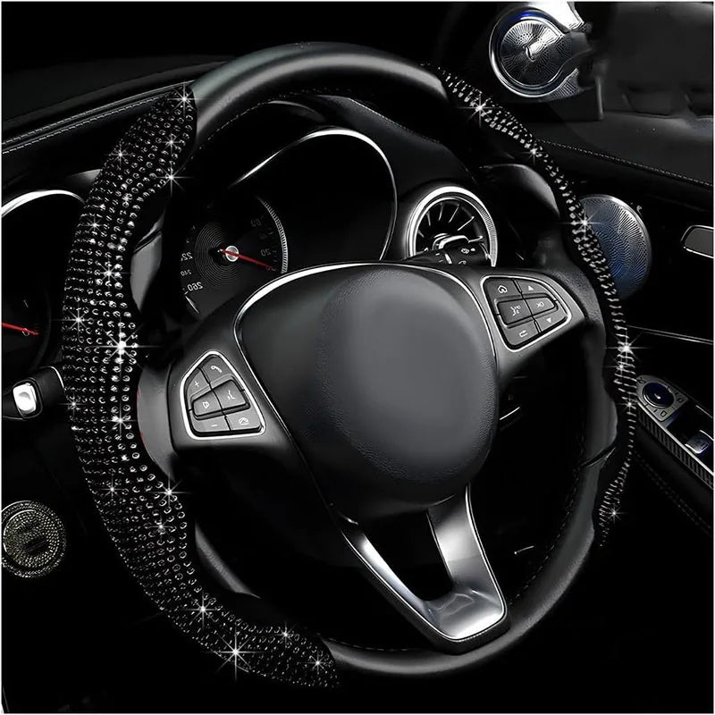 Gros plan d'une housse de volant noire incrustée de diamants à l'intérieur d'une voiture.