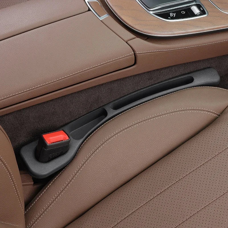 Asiento de coche de cuero marrón con relleno de hueco de almacenamiento y un pequeño objeto rojo visible en la consola.