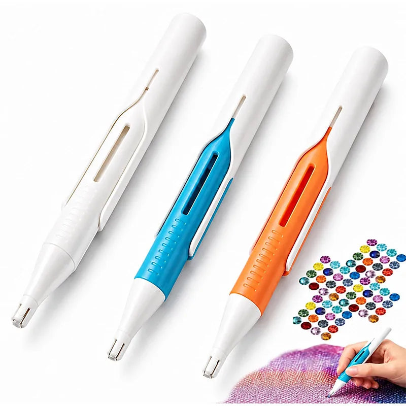 Three precision diamond painting bead dispenser pens in white, blue, and orange are shown next to a hand holding a brush.