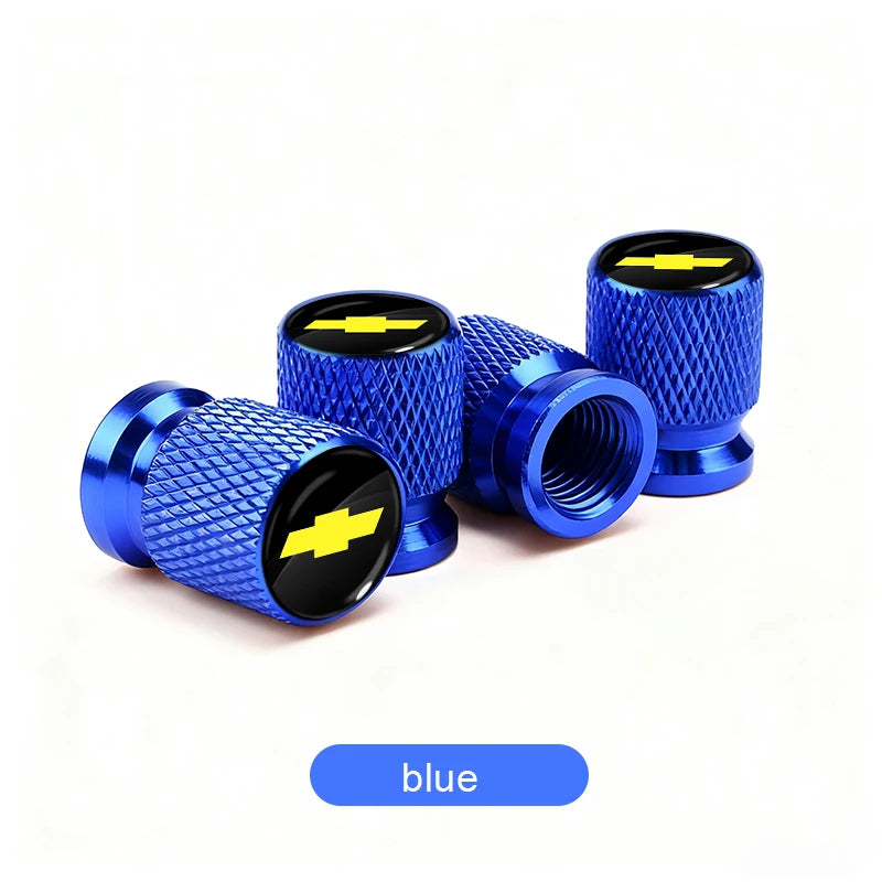A set of blue aluminum tire valve covers with a black and yellow lightning bolt design.