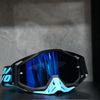 A pair of black and light blue high-performance motocross goggles resting on a dark surface.