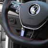Close-up of a black steering wheel cover with a silver Volkswagen logo and airbag text.