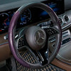 Nahaufnahme eines schwarzen Lenkrads mit lila Kohlefaser-Lederbezug in einer Luxusautosinterieur.