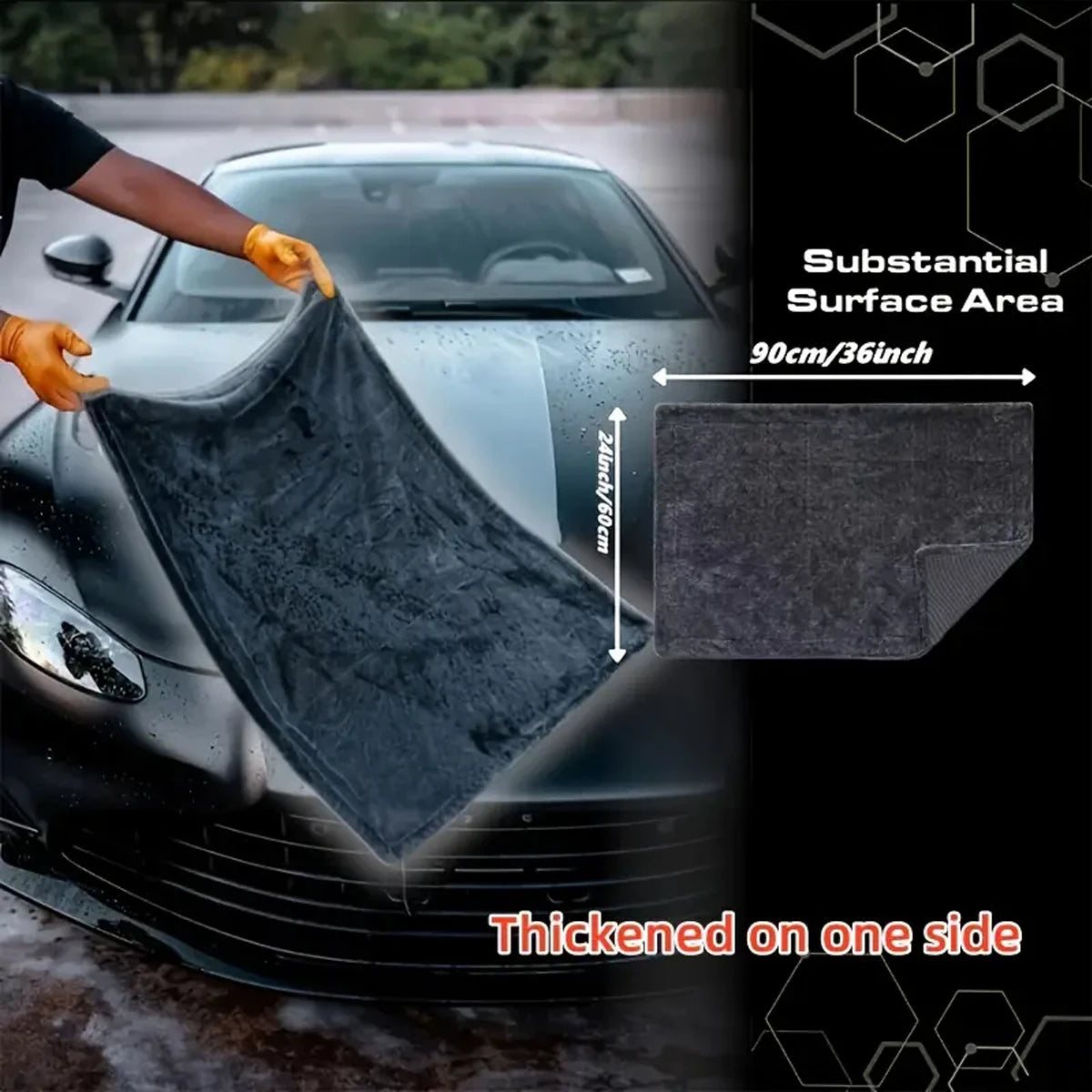 A black microfiber car drying towel is being used to wipe a car surface, highlighting its substantial area and thickness.