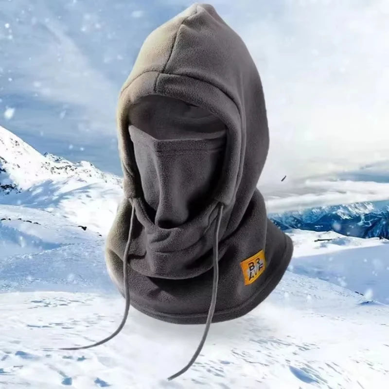 Balaclava y bufanda protectora gris contra un fondo de montaña nevada