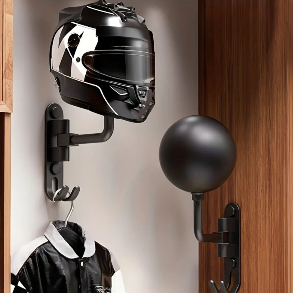 Un casque de moto noir est exposé sur un crochet mural à côté d'un luminaire rond noir.