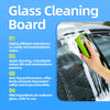 Une main utilise une brosse verte pour nettoyer les traces d'eau sur la vitre d'une voiture.