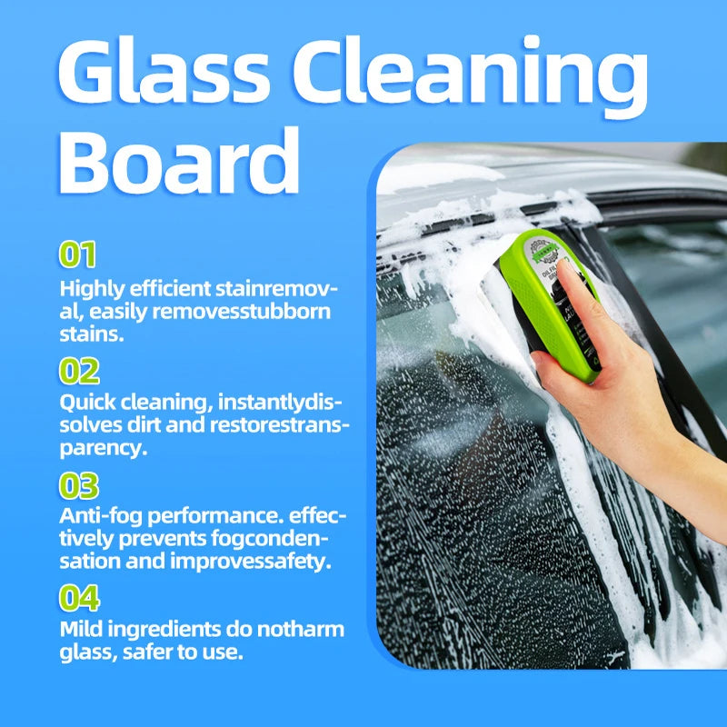 Une main utilise une brosse verte pour nettoyer les traces d'eau sur la vitre d'une voiture.